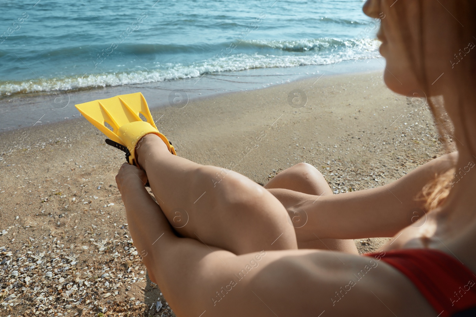 Photo of Woman wearing flippers near sea on beach, closeup