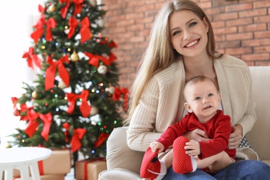 Photo of Young woman with baby celebrating Christmas at home