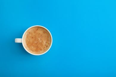 Photo of Cup of coffee on blue background, top view. Space for text