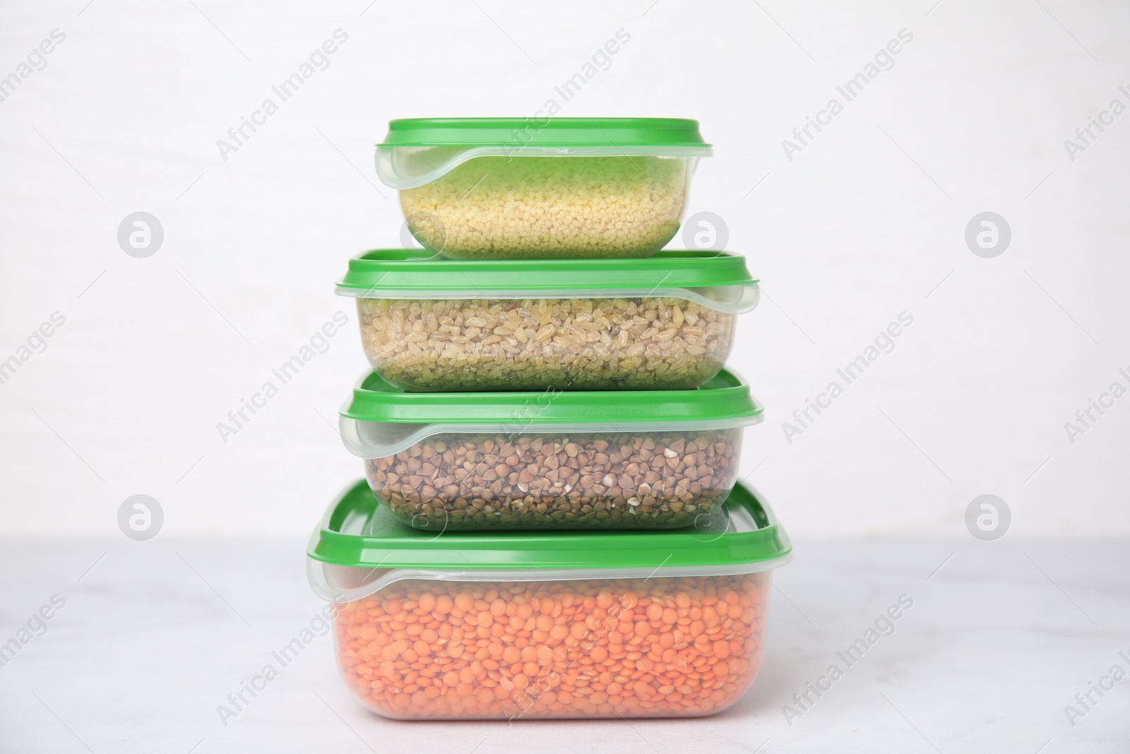 Photo of Plastic containers filled with food products on white table