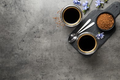 Photo of Delicious chicory drink, granules and flowers on grey table, flat lay. Space for text