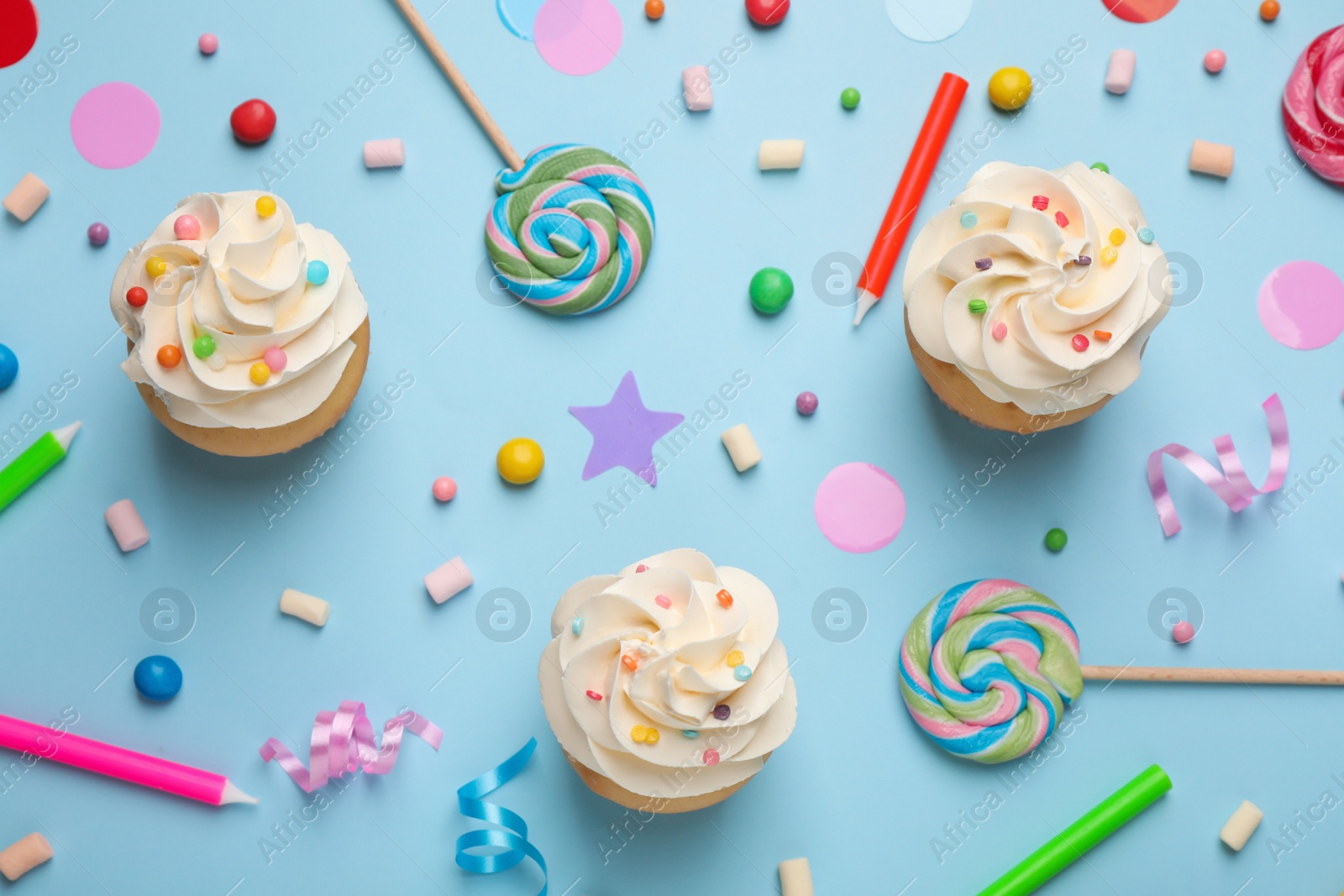 Photo of Flat lay composition with cupcakes on light blue background. Birthday party