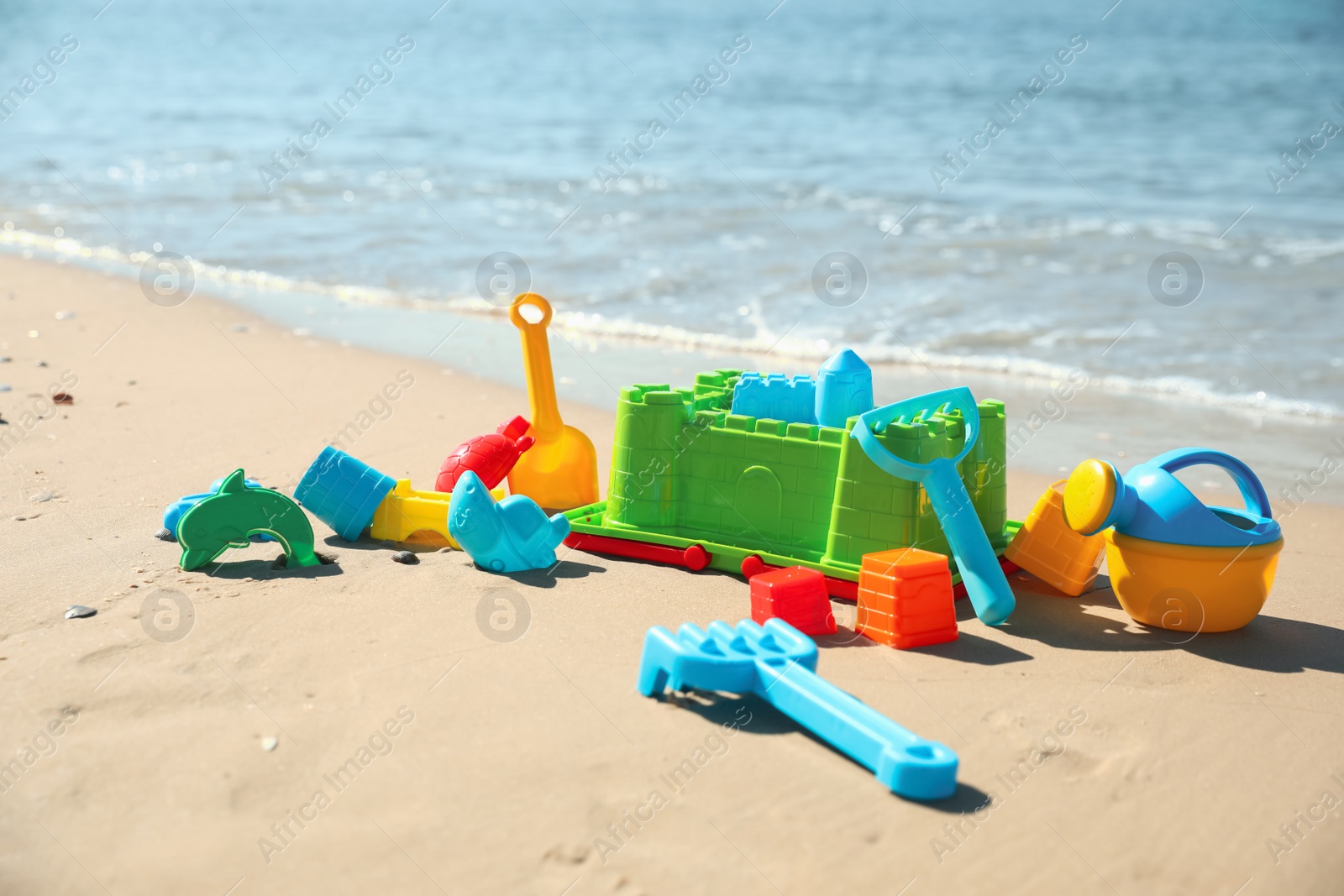 Photo of Different child plastic toys on sandy beach