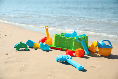 Different child plastic toys on sandy beach