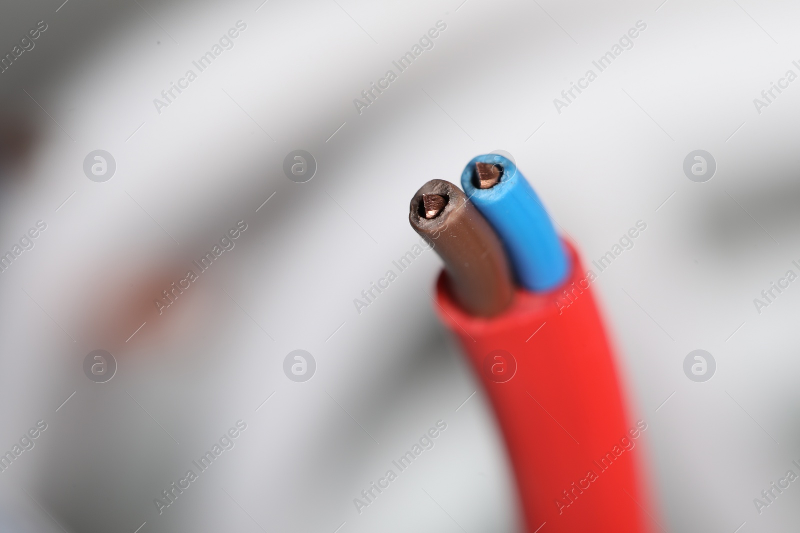 Photo of Colorful electrical wire on blurred background, closeup. Space for text