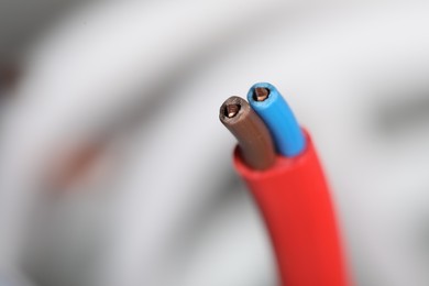 Photo of Colorful electrical wire on blurred background, closeup. Space for text