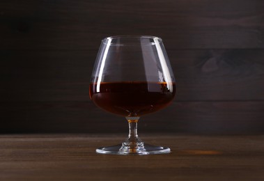 Photo of Delicious liqueur in glass on wooden table