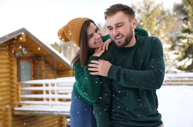 Lovely couple spending time together on snowy day. Winter vacation