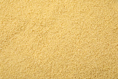 Photo of Uncooked organic couscous as background, top view