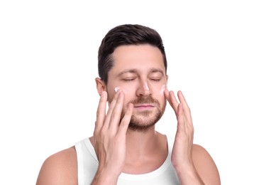 Man applying sun protection cream onto his face against white background