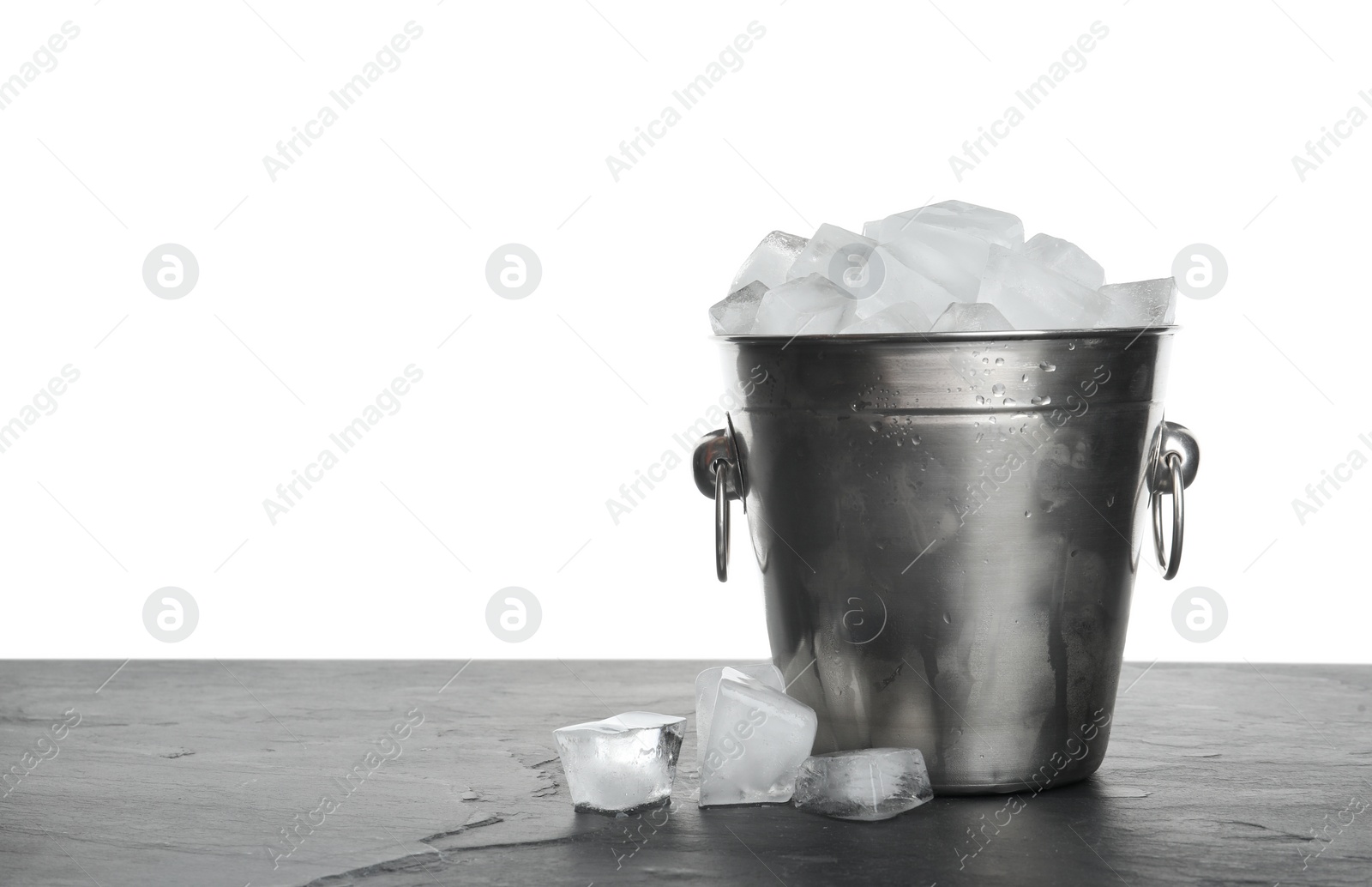 Photo of Metal bucket with ice cubes on table against white background