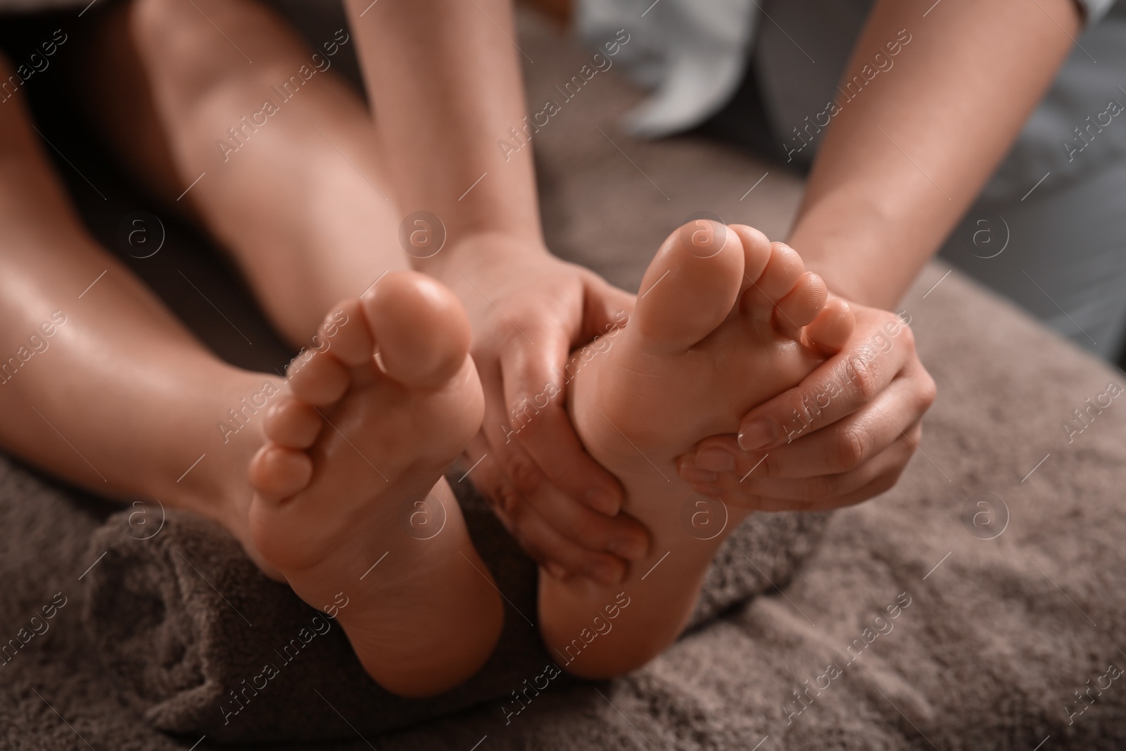 Photo of Woman receiving foot massage in spa salon, closeup