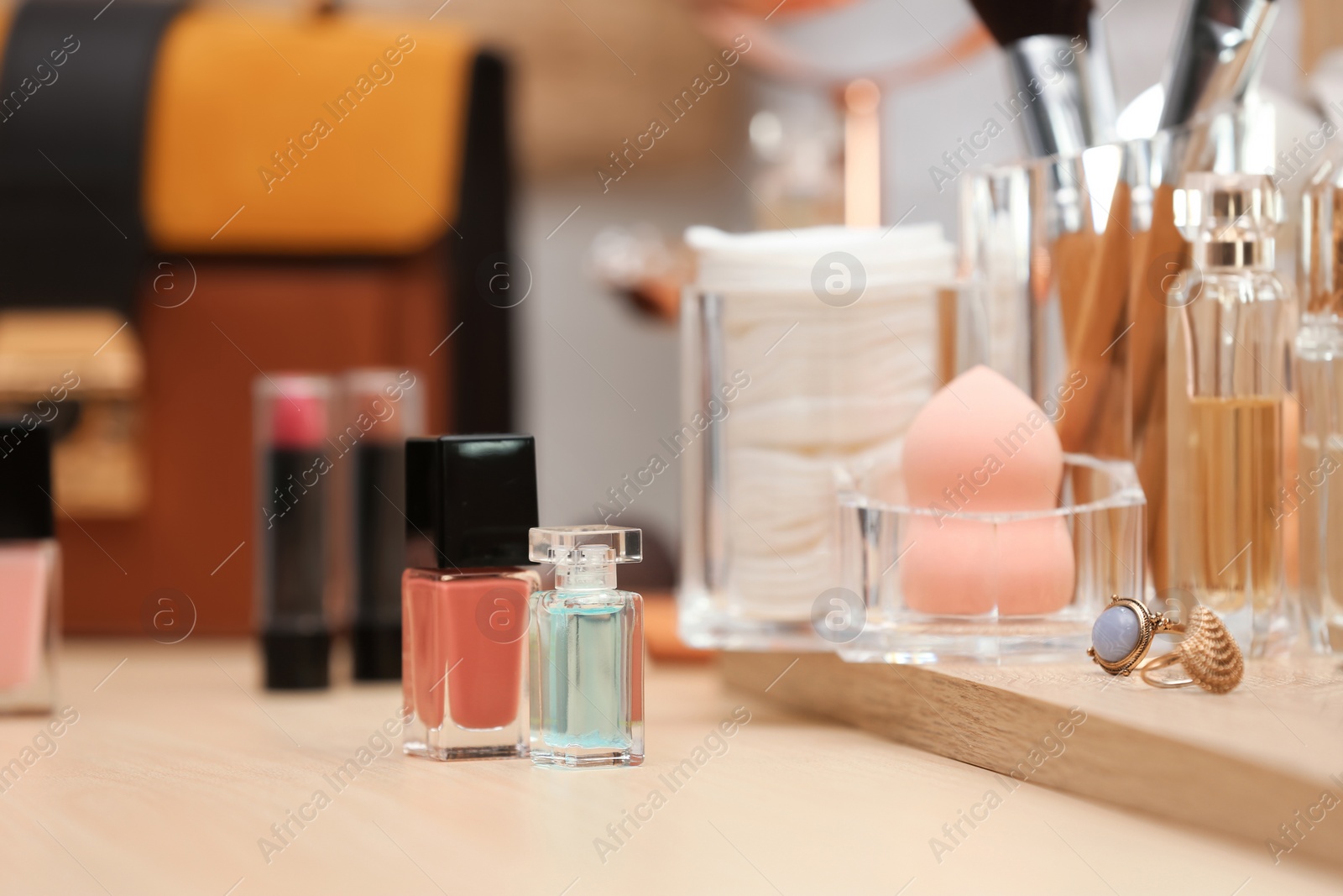 Photo of Cosmetic products, makeup accessories and jewelry on dressing table