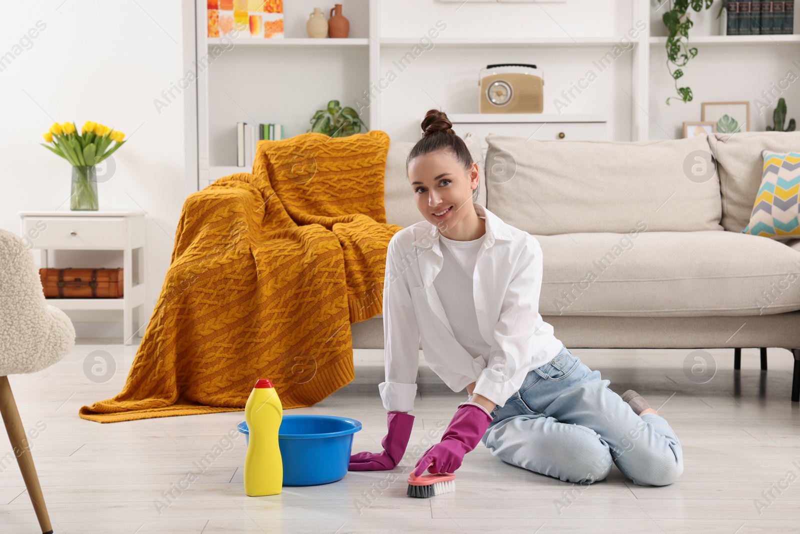 Photo of Spring cleaning. Young woman tidying up living room at home