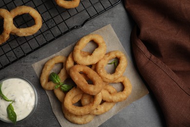 Fried onion rings served on grey table, flat lay