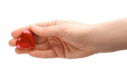 Photo of Woman holding heart shaped chocolate candy on white background, closeup