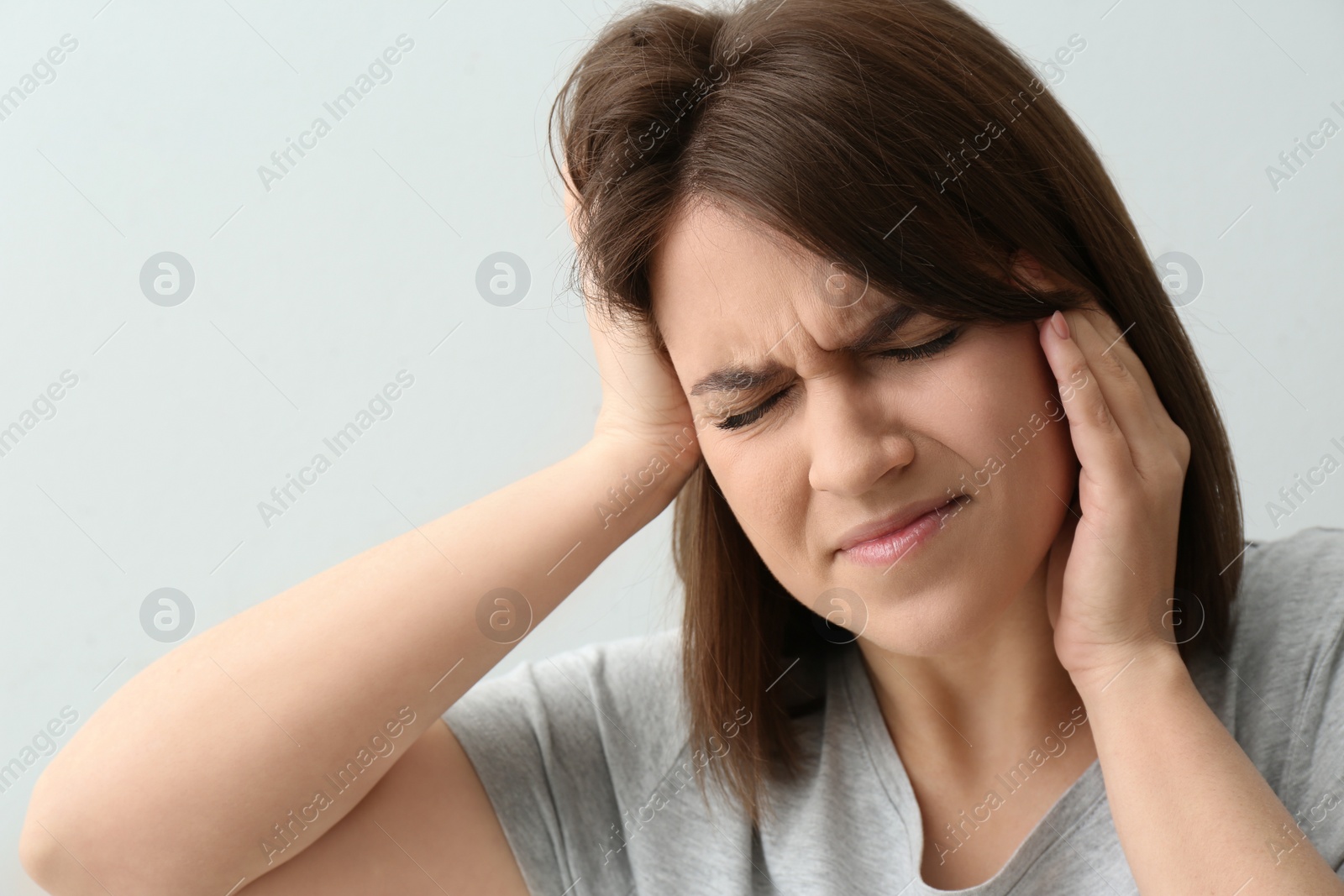 Photo of Young woman suffering from migraine on white background