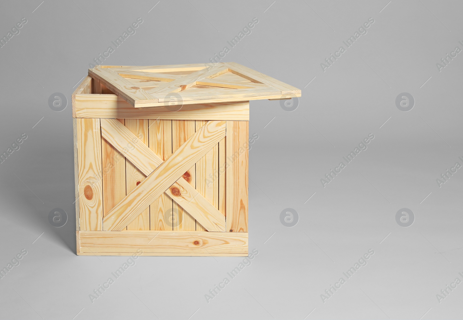 Photo of Open wooden crate on grey background. Space for text