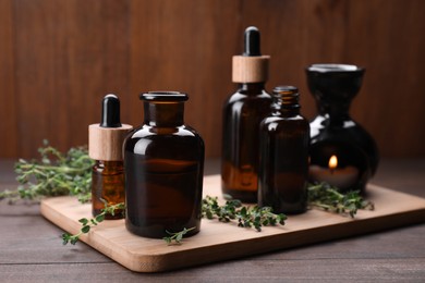 Photo of Natural thyme essential oil on wooden table