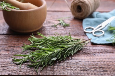 Photo of Sprigs of fresh rosemary on wooden table