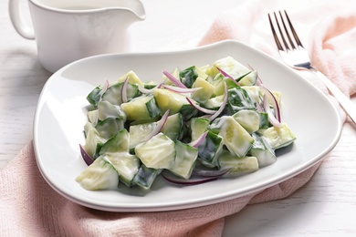 Photo of Plate with fresh creamy cucumber salad served on table