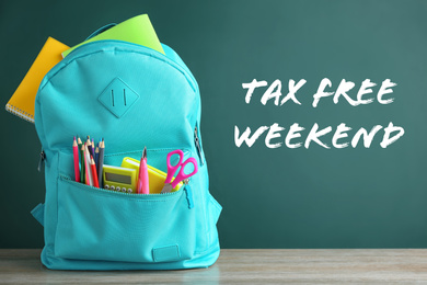 Image of Backpack with school stationery and text TAX FREE WEEKEND written on chalkboard in classroom