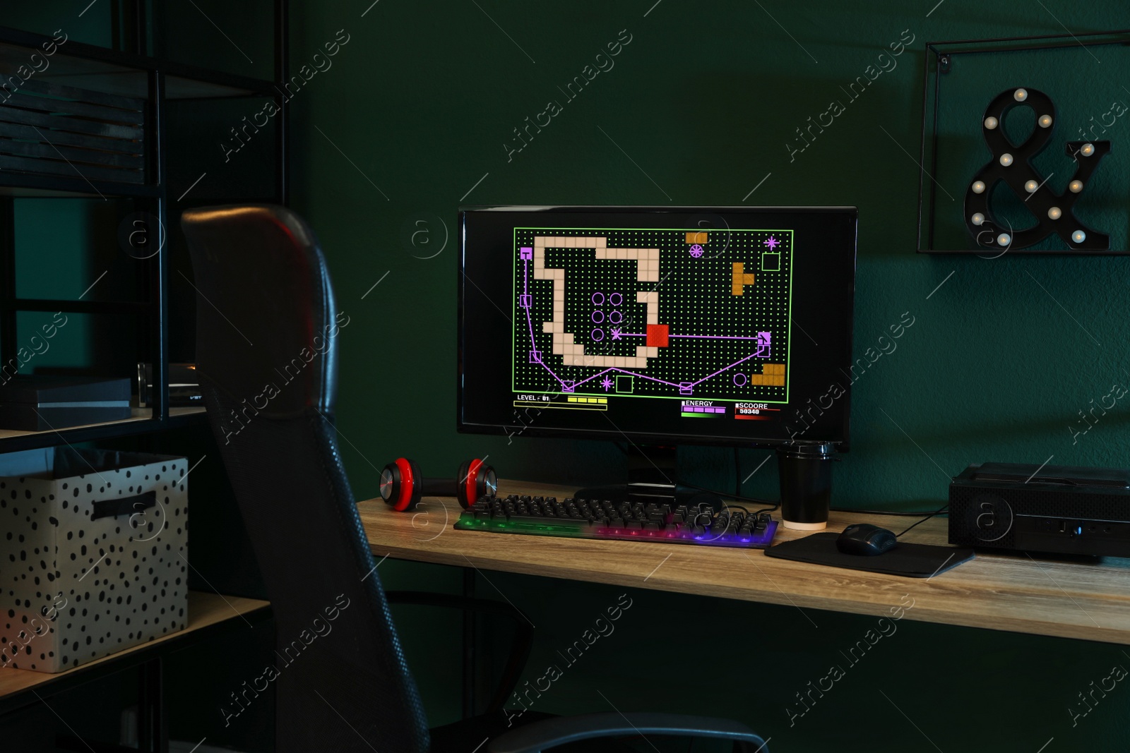 Photo of Modern computer and RGB keyboard on wooden table in dark room