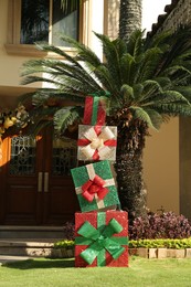 Photo of Beautiful colorful gifts near house. Festive outdoor Christmas decoration