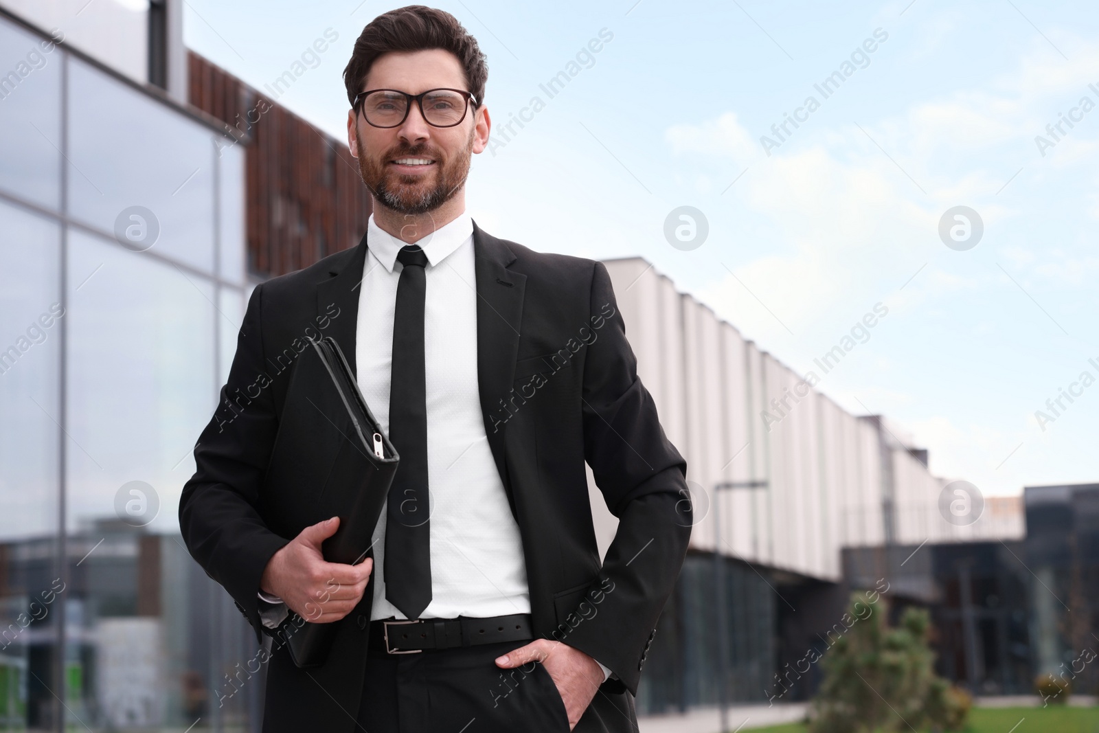 Photo of Real estate agent with leather portfolio outdoors. Space for text