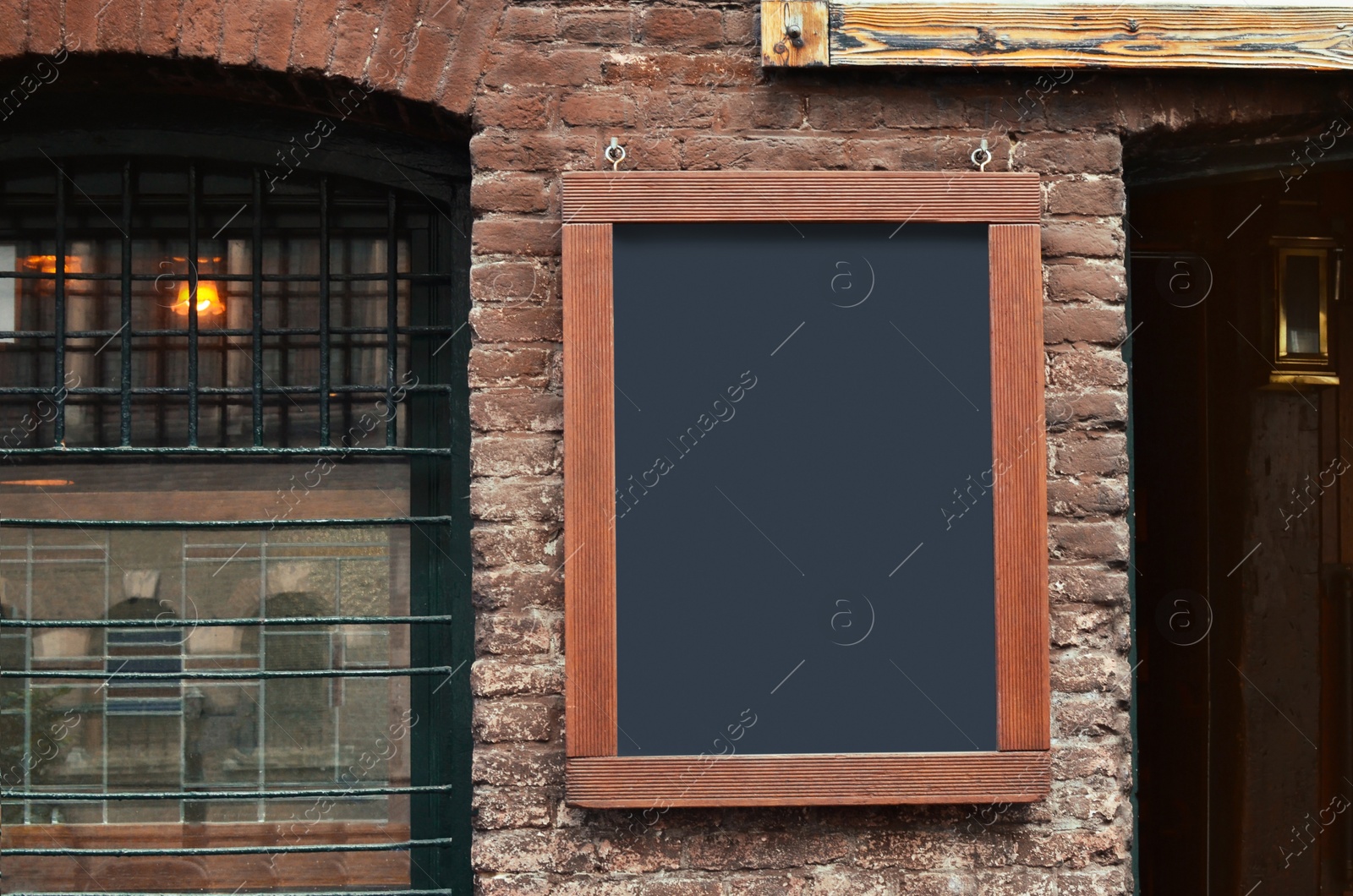 Photo of Facade of building with blank advertising board on city street. Space for design