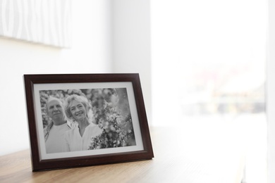 Portrait of senior couple in frame on table indoors. Space for text