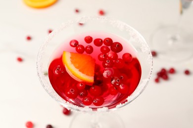 Tasty cranberry cocktail in glass on white table, above view