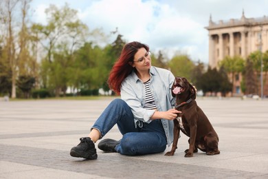 Photo of Woman with her cute German Shorthaired Pointer dog outdoors