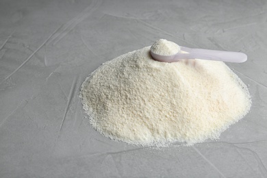 Photo of Pile of protein powder, scoop and space for text on grey background. Preparing shake