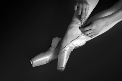 Image of Ballerina tying pointe shoes, top view. Black and white effect