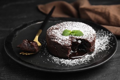 Photo of Delicious fresh fondant with hot chocolate and mint on black table, closeup