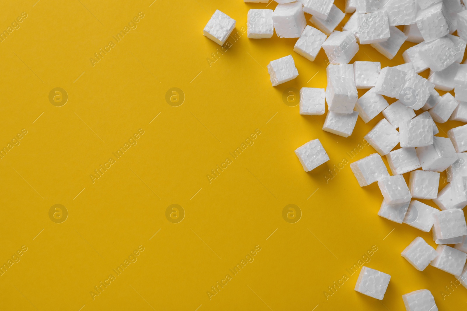 Photo of Many styrofoam cubes on yellow background, flat lay. Space for text