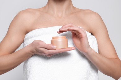 Photo of Woman with jar of body cream on white background, closeup