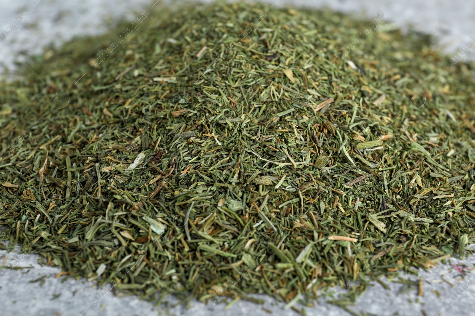 Photo of Heap of dried dill on light grey table, closeup