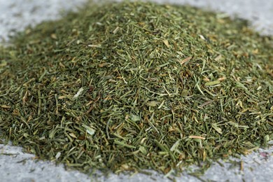 Heap of dried dill on light grey table, closeup