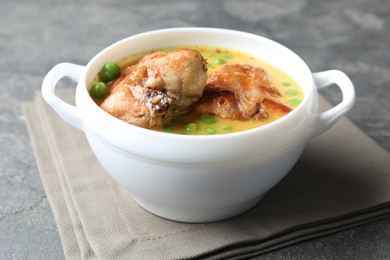Photo of Tasty cooked rabbit meat with sauce and peas on grey table, closeup