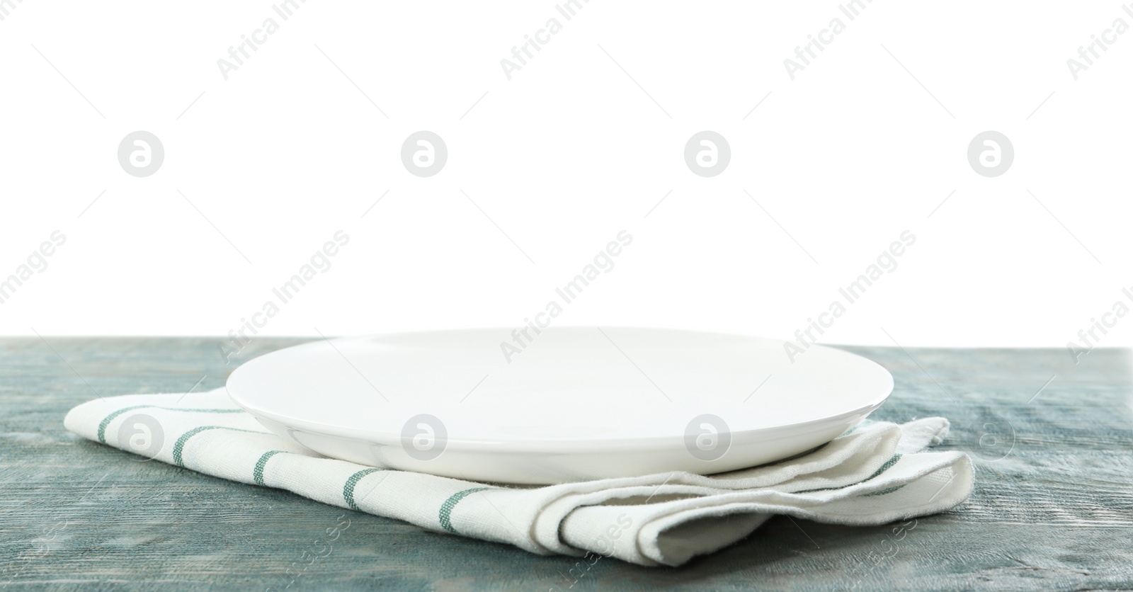 Photo of Empty plate and napkin on blue wooden table against white background