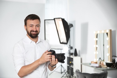 Photo of Professional photographer with camera in photo studio