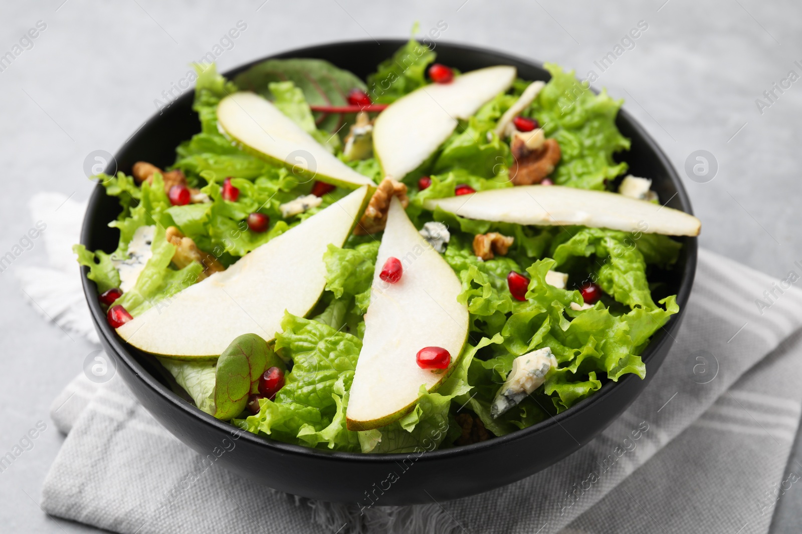 Photo of Delicious pear salad in bowl on table, closeup