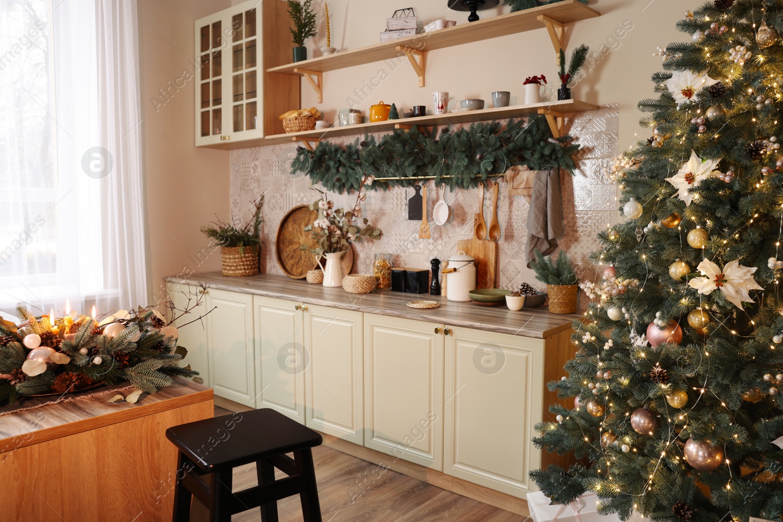 Photo of Stylish kitchen with festive decor and Christmas tree. Interior design