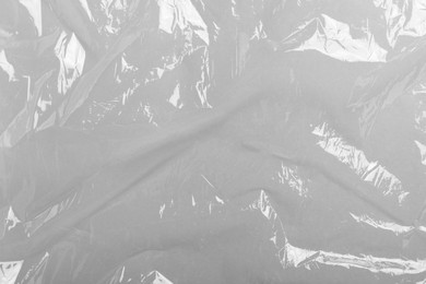 Photo of Transparent plastic stretch wrap film as background, top view