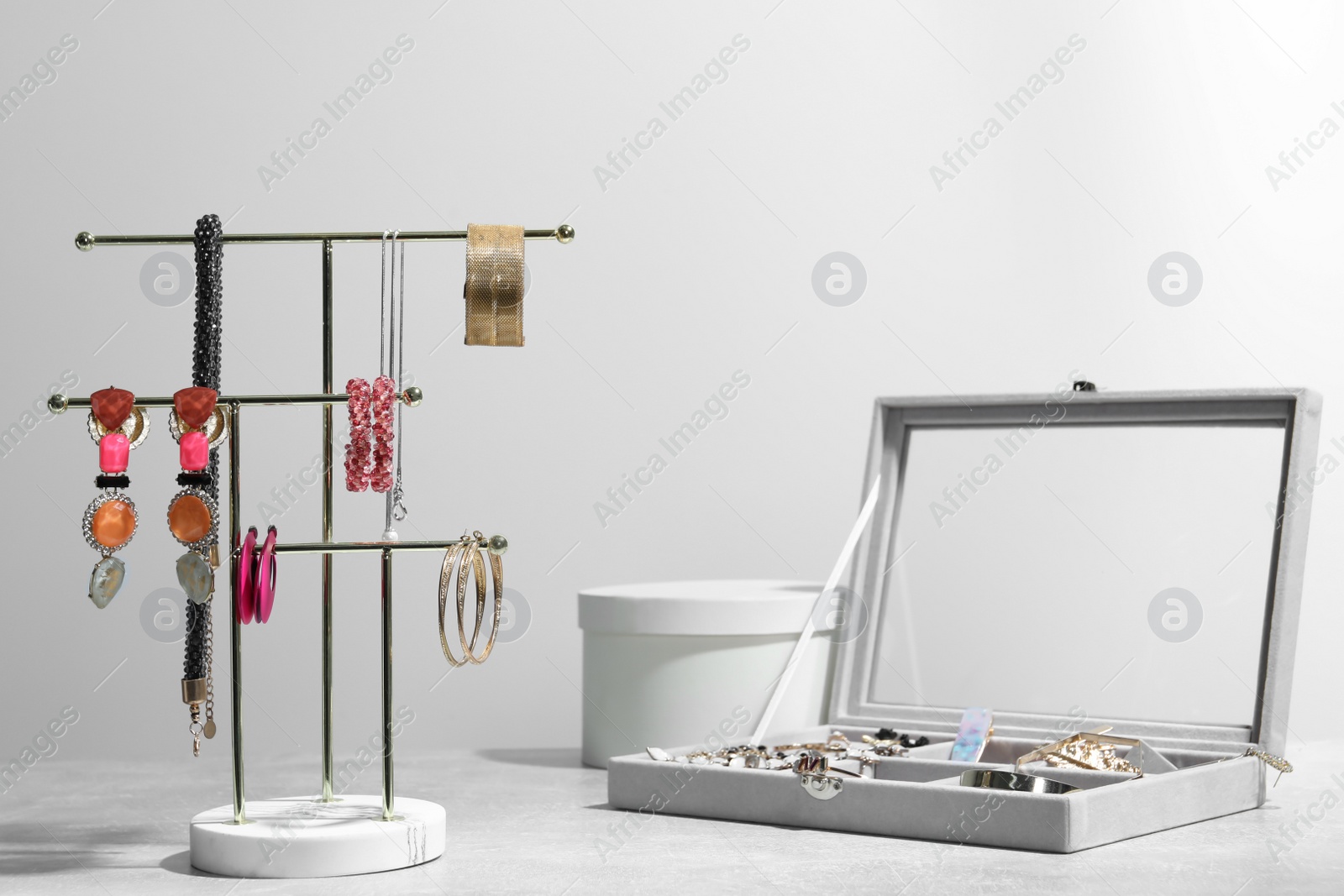 Photo of Holders with set of luxurious jewelry on light grey table