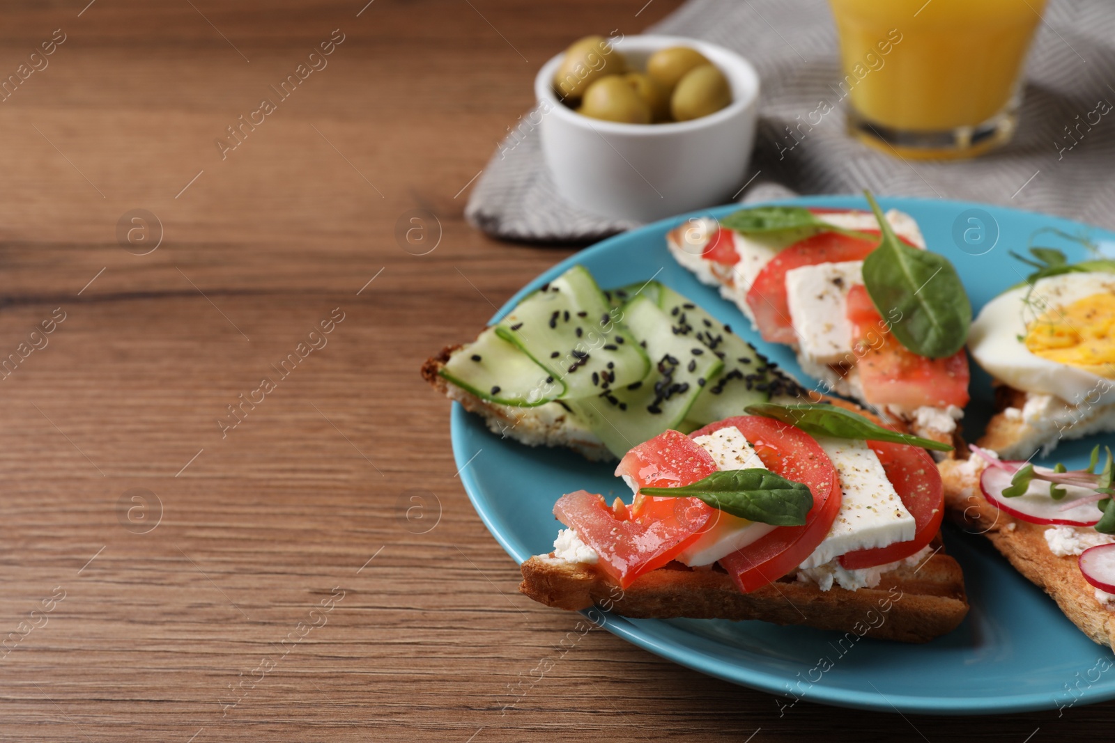 Photo of Different tasty sandwiches served on wooden table, closeup. Space for text