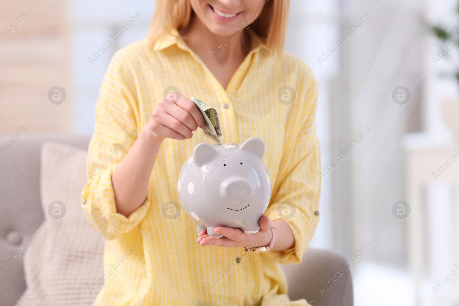 Photo of Woman with piggy bank and money at home