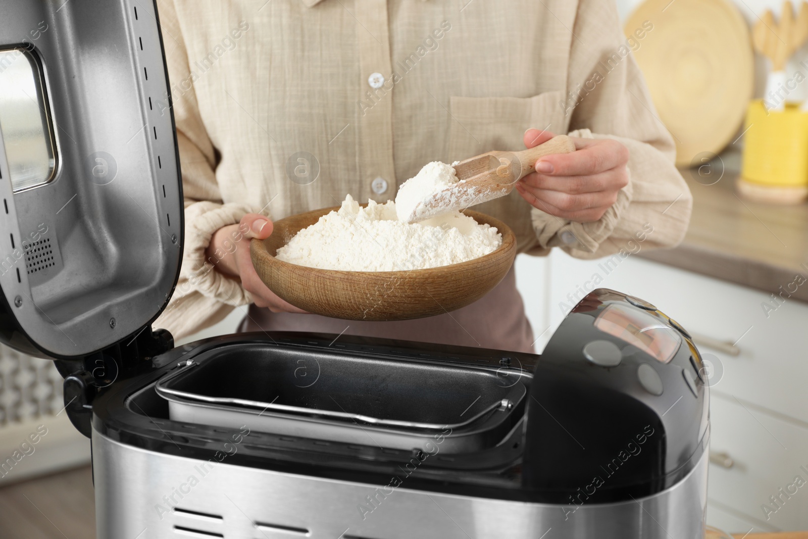 Photo of Making dough. Woman adding flour into breadmaker machine, closeup